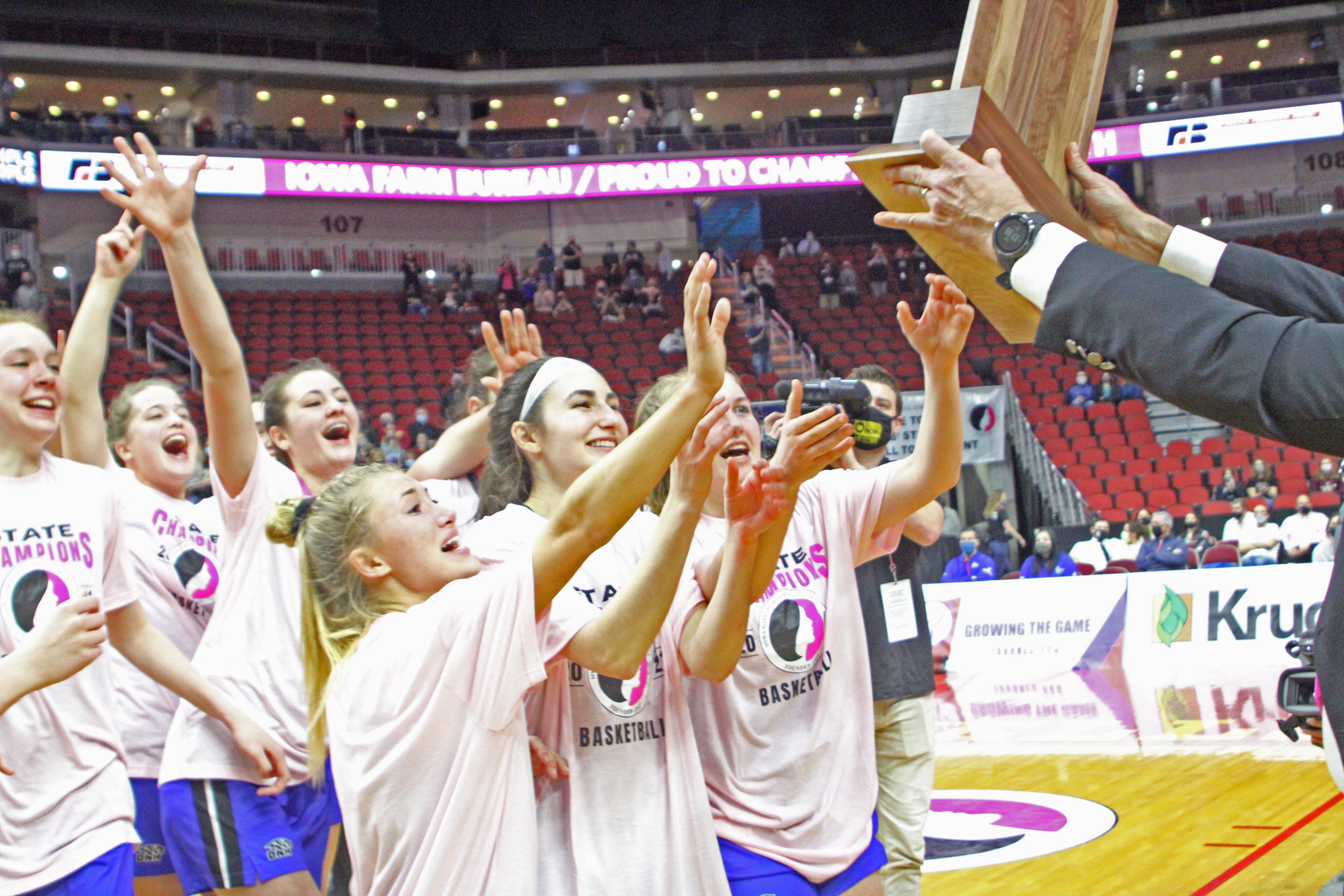 The Dike-New Hartford girls basketball team rushes to collect its Class 2A state championship trophy after an undefeated season in 2020-21. (Kristi Nixon photo)
